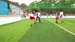 Players bounce soccer ball off wall, goalie saves in local football match Stock Footage
