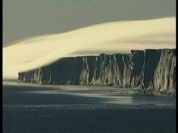 WA ice cliffs casting shadows over water, katabatic winds flowing over cliff, Antarctica Stock Footage