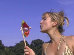 Woman blowing pinwheel; UK Stock Footage