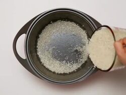 CU Hands pouring rice in pan from beaker / Seoul, South Korea Stock Footage