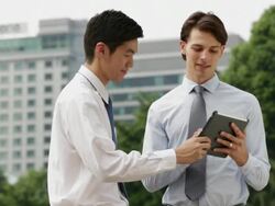 MS Two businessmen working on a digital tablet outdoors. Stock Footage