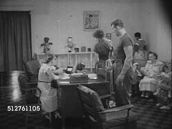 1953: BABY CLINIC: Mother's w/ babies, toddlers, children in waiting room, couple w/ child entering clinic, checking in w/ receptionist, handing her booklet (possibly immunizations, vaccinations, check-up lists). Instructional Video