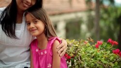 Young hispanic girl and older sister smile at camera Stock Footage