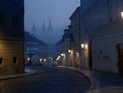 Long shot view of curving street on foggy day at twilight / Prague Stock Footage