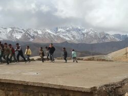 MS Shot of children running and playing on old home foundation with atlas clouds moving over mountains / Marrakech, Tensift, Morocco  Stock Footage