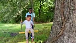 MS PAN Smiling young boy being pushed on swing by father in backyard Stock Footage