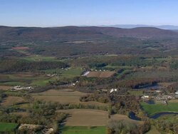 WS AERIAL Wooded area with autumn colors and small town nestling in trees / Massachusetts, United States Stock Footage