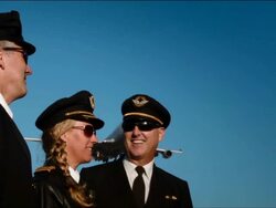W/S three airline pilots, one female - two male, watch as airplane passes overhead: Boeing-747 Stock Footage