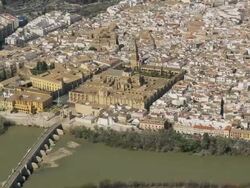 aerial view of historic city center with Cathedral-Mosque in center and Roman bridge spanning Guadalquivir river Stock Footage