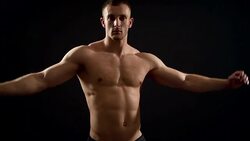 healthy athlete shows good muscle on black background Stock Footage