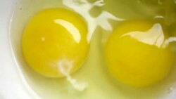 Slow motion of two eggs in bowl Stock Footage