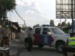 Merapi volcano erupts whilst police man a checkpoint in Yogjakarta city; Indonesia. 7 November 2010 / AUDIO Stock Footage