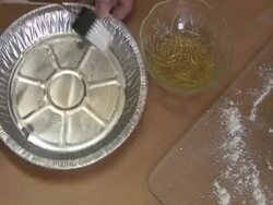 Brusing olive oil in a pie tine Stock Footage