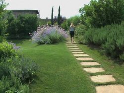 Blond woman walking in a marvelous flowered Tuscan garden Stock Footage