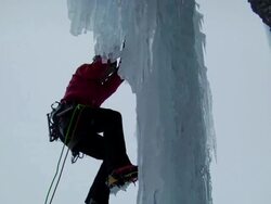 MS PAN Looking up on ice climber steps off ground and begins climbing an ice pillar / Stanley Headwall Valley,British Columbia,Canada Stock Footage