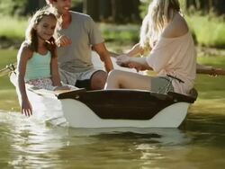 WMS of family rowong boat on lake Stock Footage