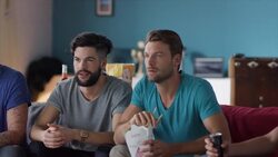 Guys sitting on couch watching tv and cheering Stock Footage