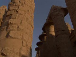 Low Angle, tilt-up tracking-left - Spires of old adobe buildings stand against a clear blue sky / Egypt Stock Footage