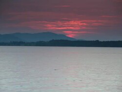 WS View of Pink sunset over Lac Brome lake with mountains in distance / Knowlton, Quebec, Canada Stock Footage