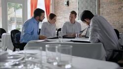 Restaurant staff discuss menu items with business owner in daily meeting Stock Footage