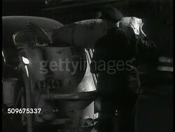 1943: SWEDEN: FUEL SHORTAGE: Man dumping bag of coal into barrel on front of converted car, alternative fuel source, no gas. Sign 'Retortkol 5.25' (gas coal). MS Male dumping bag of coal into bin on back of car. WS Modified cars moving up road. WWII. Instructional Video