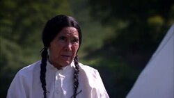 Seated Native American Indians with male talking to older male whilst woman uses pestle and mortar Stock Footage
