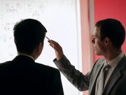 MS Two businessmen discussing and pointing on whiteboard / China Stock Footage