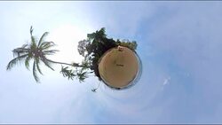 Small Planet Effect of a man sitting on the beach Stock Footage