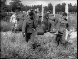 B/W 1961 PAN from soldiers unrolling barbed wire for fence of Berlin Wall to crowd watching Stock Footage