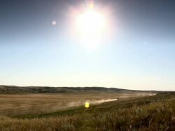 A truck moves away on a road surrounded by fields in the prairies Stock Footage