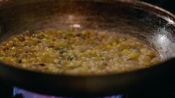 In restaurant kitchen, corn succotash sizzles on gas stove top in slow motion Stock Footage