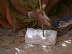 CU Shot of hands twisting stick through stone to make hole through beads / Limpopo, South Africa Stock Footage