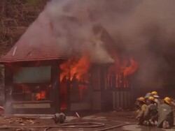 MS PAN ZO Firemen working on burning rural information booth / Unspecified Stock Footage
