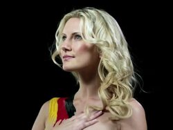 Woman with German flag painted on shoulder, hand on chest Stock Footage