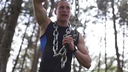Attractive male doing weight lifting with a chain outdoors in a nature Stock Footage