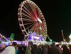 WS LA Shot of Ferris wheel and people passing by at fun fair / Cologne, Germany Stock Footage