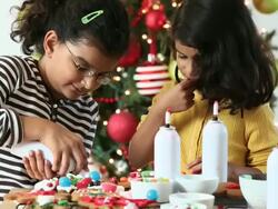 MS Two Young Sisters Decorating Gingerbread Cookies for Christmas / Richmond, Virginia, United States Stock Footage