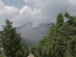 Rural road leads to smoking crater of Sakurajima volcano, Japan Stock Footage
