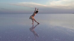 Young ballerina solo dancing on the salt lake Stock Footage