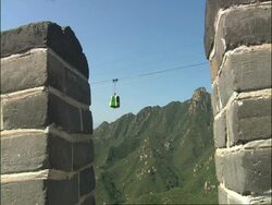 View from Great Wall of China battlements across to cable car and mountains, Badaling, China Stock Footage