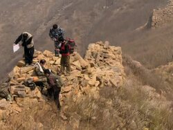 5 Chinese men sitting on a pile of rocks from the Great Wall of China. Stock Footage