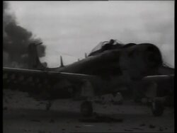 B/W 1960's military airplane taxiing past camera / fire background / Vietnam / SOUND Stock Footage