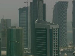 MS AERIAL DS ZI ZO Shot of skyscraper in city near ocean / Qatar Stock Footage
