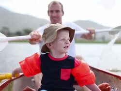 Father and son on a paddle boat in the water Stock Footage