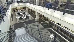 Stairs lead down to rows of cubicles inside an office building. Stock Footage