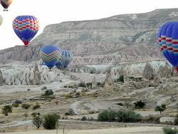 WS T/L View of Hot Air Balloons Rise over Goreme Town in Cappadocia / Goremel, Turkey Stock Footage