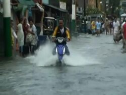 Motorbike speeds through flood waters in Cupang in aftermath of typhoon Mirinae, Philippines, 2009 Stock Footage