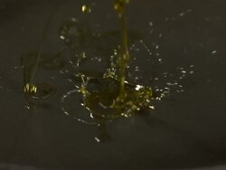 High speed oil falling on to surface of frying pan Stock Footage