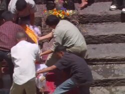 MS ZO Men lifting  deceased woman off  plank and begin to carry it up stone steps  / Kathmandu, Central, Nepal Stock Footage