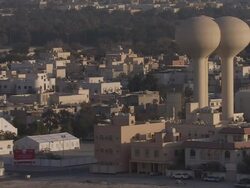 WS ZO View of  desert town with low buildings and two bulbous water towers / Manamba ,Bahrain Stock Footage